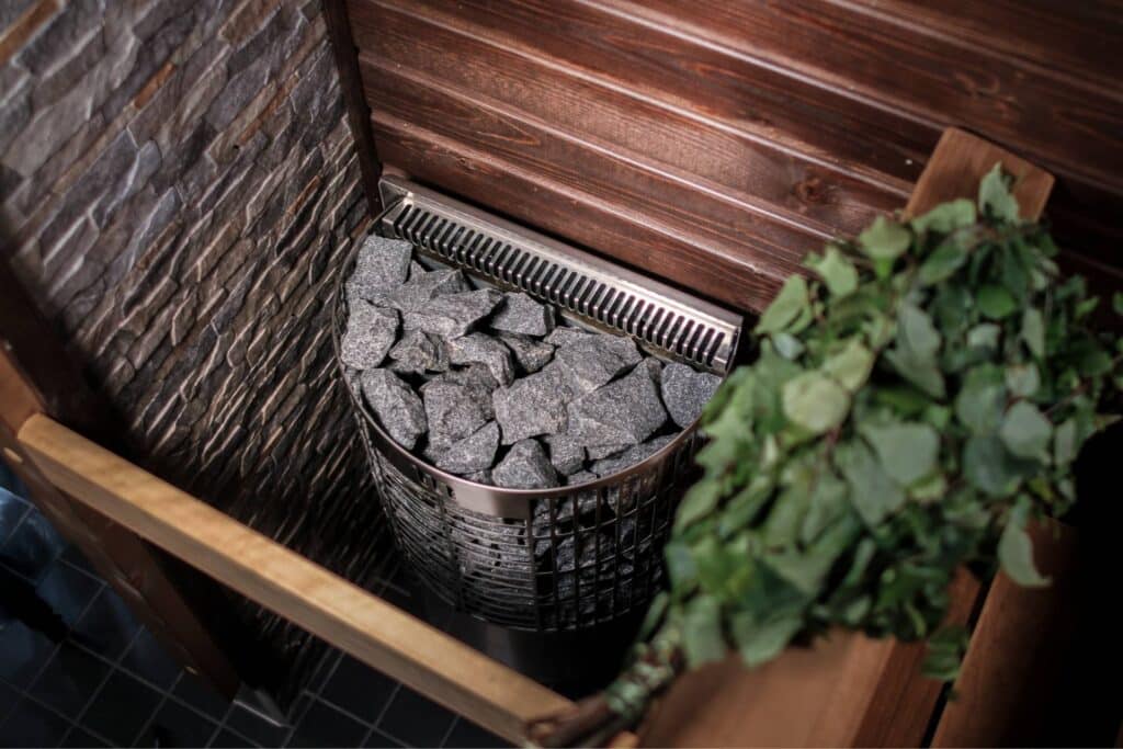 Titelfoto für den Artikel "Weihnachtssauna und ein Rückblick auf die Weihnachtssaunapflege", mit Mondex Teno-Saunaofen und getrocknetem Sauna-Aufgussbesen.