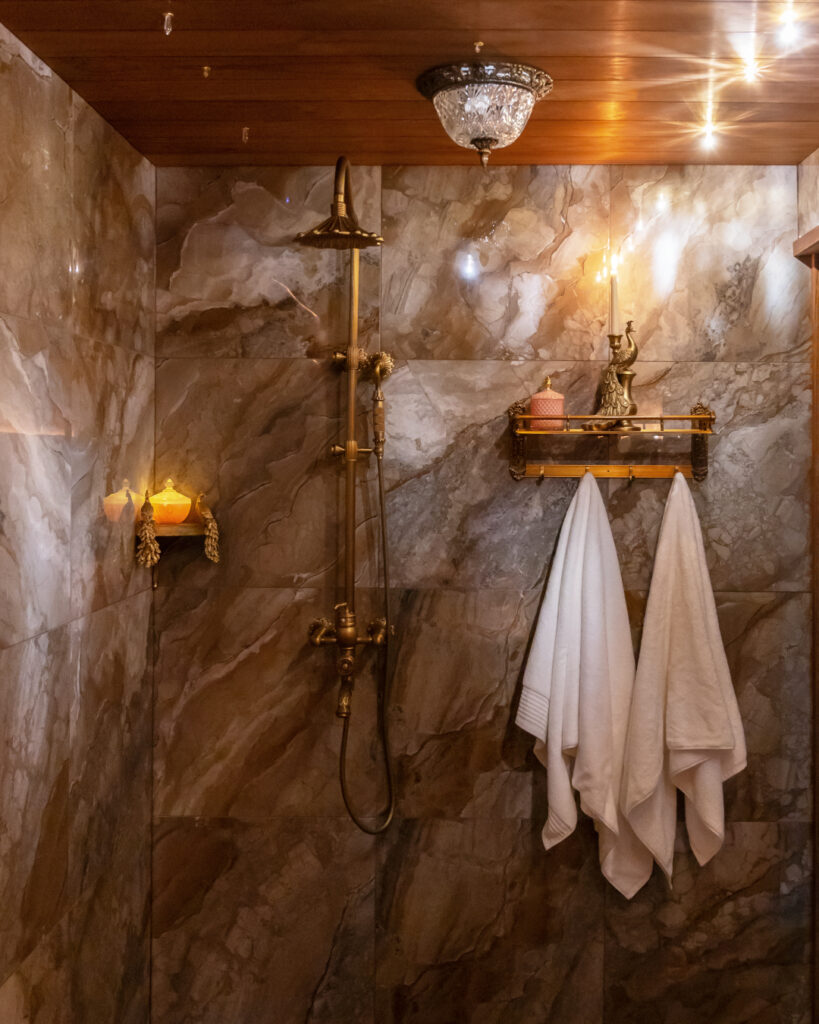 Striking stone tiled wall in a warmly lit bathroom.